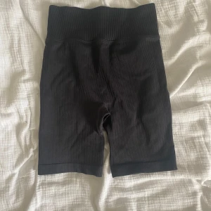Svarta ribbade cykelshorts  - Svarta ribbade cykelshorts i storlek XS. De är högmidjade och har en tight passform med stretchigt material som sitter skönt.