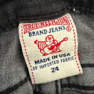 Grå skinny jeans från True Religion - Säljer ett par grå skinny jeans från True Religion med klassiska broderade bakfickor och snygga detaljer på fickorna fram. Jeansen har normal passform och är tillverkade i mjukt denim-material. Perfekt för dig som gillar stilrena och coola jeans.