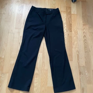 Lågmidjade Kostymbyxor - Snygga svarta kostymbyxor från H&M i storlek 36. Byxorna har raka ben med lätt bootcut, bälteshällor och klassisk knapp- och dragkedjestängning. Materialet är mjukt och känns dressat, perfekt till en cool look. Köpt secondhand men säljer då de var något för små för mig. Inga defekter alls vad jag har sett. Hör av er om ni har några funderingar eller vill ha någon form av annan bild!