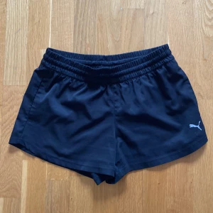 Svarta träningsshorts från Puma - Snygga svarta träningsshorts från Puma med snörning i midjan. Perfekta för gymmet eller löprundan! 