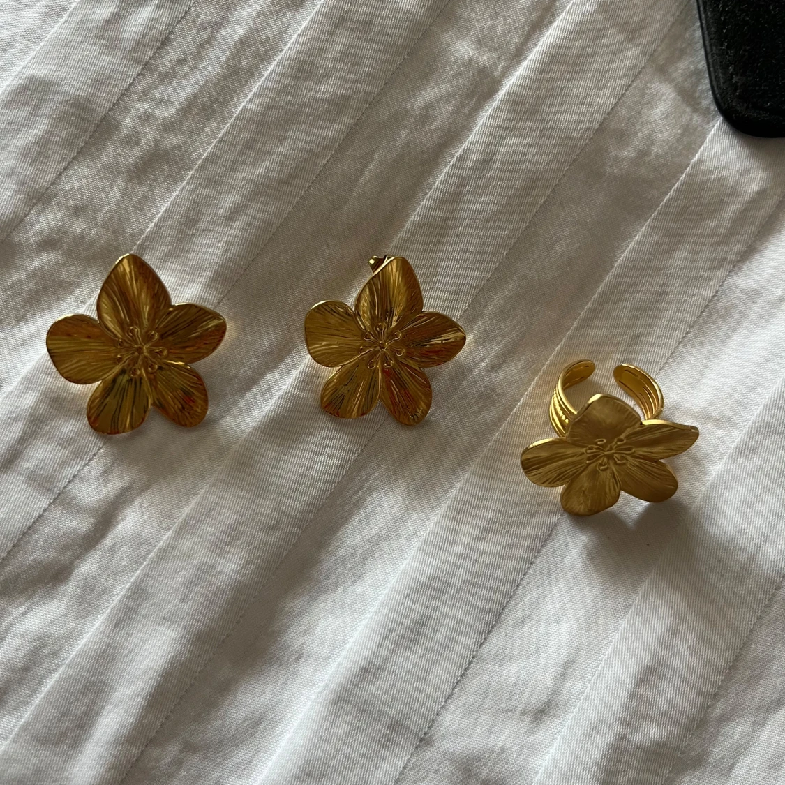 Guldiga blomformade örhängen och ring