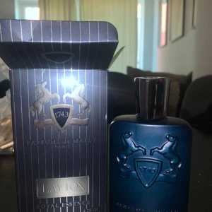 Parfums de Marly Layton EdP - Lyxig parfym från Parfums de Marly, Layton Royal Essence. Flaskan är mörkblå med silverdetaljer och har en elegant, maskulin design med två upphöjda hästar och sköld. Kommer i originalkartong med samma stilrena look.