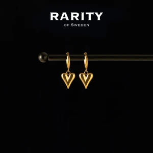 Heart Earring - Gold: Guldiga hjärtörhängen  - Snygga örhängen i guldton från Rarity of Sweden med hängande hjärtan. De har en klassisk rund ring och ett stilrent hjärta som hänge, perfekta för att ge din look en extra touch av kärlek och elegans.