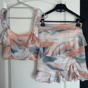 Pastellfärgad croppad topp med matchande kjol - Säljer min croppade topp med breda axelband och volangdetaljer samt matchande kjol. 