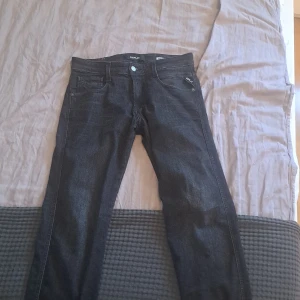 Replay Anbass Slim Fit jeans svart - Snygga svarta Replay Anbass jeans i slim fit-modell. Klassisk femficksdesign, raka ben och diskreta detaljer. Jeansen är tillverkade i ett mjukt och stretchigt bomullsmaterial som sitter skönt hela dagen. Perfekta för dig som gillar en stilren look. Hör av dig i pm vid intresse, dem är inköpta för cirka 5 månader sedan.