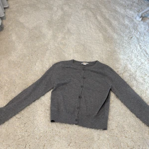 Grå kofta från Gina Tricot - Snygg grå kofta från Gina Tricot med rund halsringning. Använd men märks inte av.