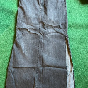 Svart lång jeanskjol från ONLY - Säljer en svart lång jeanskjol från ONLY med rak passform och snygga höga  slitsar på sidorna. Stretchig!  Kjolen har klassiska jeanssömmar och är perfekt för dig som gillar en stilren och cool look.