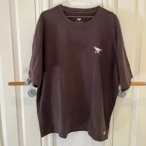 Brun DJI t-shirt med drönarmotiv - Säljer en brun t-shirt från DJI med coolt drönarmotiv och tekniska detaljer tryckta på ryggen. Tröjan är väldigt tjock, så superbra vinter-tshirt!