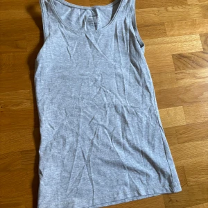 Grå linnetopp från Newbody XS - En basic grå linnetopp från Newbody i storlek XS. Toppen är ärmlös med rund halsringning. Aldrig använd. 