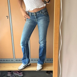 Blå bootcut jeans från Miss Sixty - Snygga blå jeans från Miss Sixty med låg midja och bootcut-ben. Jeansen har klassiska fem fickor, slitningar och ljus tvätt för en cool vintagekänsla. Materialet är mjukt denim i bomull med lite stretch för skön passform.