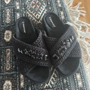 Svarta sandaler från Depeche med pärlor - Snygga svarta sandaler från Depeche med grovstickade korsade band och svarta pärldetaljer. Köpte för 300 ungefär och dom e helt oanvända. Därav priset.
