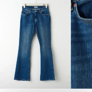Blå bootcut jeans med utsvängda ben - Snygga blå jeans med bootcut-modell och utsvängda ben. Klassisk femficksdesign och normal midja. Jeansen har en lätt tvättad look och är perfekta för dig som gillar en retrostil.
