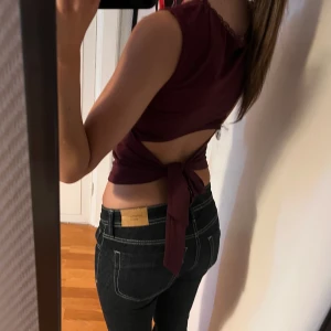 Vinröd linnetopp med öppen rygg och knyt - Säljer en vinröd linnetopp med fyrkantig ringning och spetskant. Toppen är ärmlös och har en snygg öppen rygg med knytband. Aldrig använt så det är inga fläckar eller liknande. Pris kan diskuteras🥰