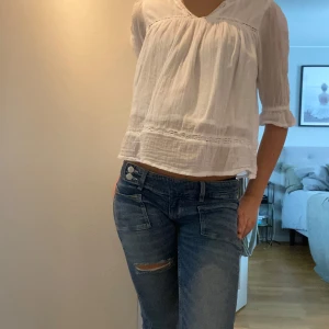 Vit blus med spets från Gina Tricot - Superfin vit blus från Gina Tricot i strl 158/164, sitter som XS, med spetsdetaljer och trekvartsärm. Blusen har en lös passform och volang vid ärmslut och nederkant. Perfekt för en sommardag eller till skolan💗