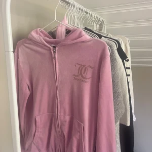 Rosa velourjacka Juicy Couture - Säljer en ikonisk rosa velourjacka från Juicy Couture med huva och dragkedja. Jackan har JC-logga broderad på bröstet och två fickor framtill. Storleken är 12-13 år men tycker den är ganska stor och sitter som en vanlig XS. 