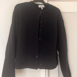 Svart kofta från & Other Stories - Mysig mörkblå kofta från & Other Stories med rund halsringning och knappar framtill. Koftan är stickad och har lång ärm, perfekt för lager-på-lager och chill vibes. Enkel och stilren design som funkar till allt. Skick 10/10.