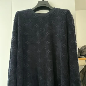 Mörkblå Louis Vuitton tröja - Exklusiv mörkblå frotté tröja från Louis Vuitton med ikoniskt monogrammönster över hela plagget. Storlek xl men sitter lite mindre så perfekt för dig som har Large. Pris kan diskuteras vid snabbaffär