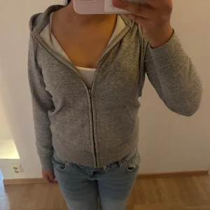Grå hoodie med dragkedja - Mysig grå hoodie från uniqlo med huva och dragsko, hel dragkedja framtill och två stora fickor. Är i storlek L men skulle nog säga den är mer som en M❤️ den är sparsamt använd
