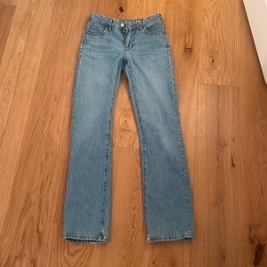 Ljusblå low waist straight jeans från bikbok - Ljusblå jeans med låg midja och raka ben. Stängs med dragkedja och knapp framtill. Midja 24, längd 32.