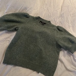 Grön stickad tröja Vero Moda puffärm - Storleken är felmärkt storleken är egentligen XS, sa dom till mig i butiken!!Mysig grön stickad tröja från Vero Moda med puffiga korta ärmar och ribbade muddar. Perfekt för lager-på-lager och ger en chill men ändå trendig vibe. Rund halsringning och relaxed fit gör den superenkel att styla till jeans eller kjol.💚