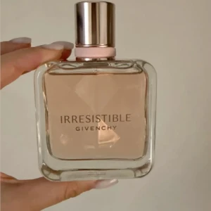 Givenchy Irresistible Eau de Parfum - Givenchy Irresistible Eau de Parfum i en lyxig fyrkantig glasflaska med ljusrosa doft och elegant silver- och roséguldfärgad kork. Snygg och feminin design, perfekt för dig som gillar exklusiva parfymer med modern känsla.