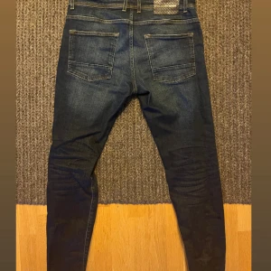 Mörkblå skinny jeans från Goldgarn - Snygga mörkblå jeans från Goldgarn Denim med klassisk femficksdesign och kontrastsömmar. Modellen är skinny fit med smala ben och normal midja. Jeansen har en stilren look och är perfekta för dig som gillar en tajt passform. Storlek i jeansen w31/32 men sitter som 30/30