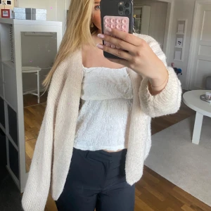 Beige stickad cardigan jacka från Lindex - Mysig och oversized beige stickad cardigan jacka från Lindex. Den har lång ärm, öppen framtill och är gjord i ett fluffigt, mjukt material. 