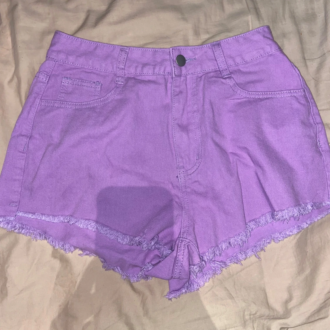 Lila jeansshorts med fransig kant