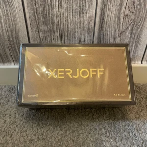 Xerjoff Alexandria II Parfum 100ml - Lyxig parfym från Xerjoff, Alexandria II Parfum i en elegant mörkbrun och guldig kartong. Flaskan rymmer 100 ml (3.4 fl.oz) och förpackningen har exklusiva gulddetaljer och mönster. Perfekt för dig som gillar exklusiva dofter och snygg design.