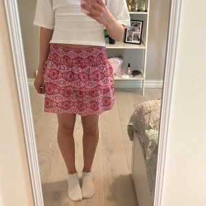 Rosa mönstrad volangkjol - Rosa mönstrad volangkjol i storlek xs. Aldrig använd, bra skick. 90kr