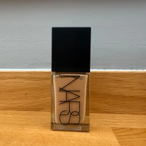 NARS Light Reflecting Foundation - Säljer en NARS Light Reflecting Foundation i färgen Barcelona. Den är täckande men ger samtidigt en naturlig finish med glow. Perfekt för dig som vill ha en lätt och glowy bas. Nypris 665kr och endast använd en gång. 