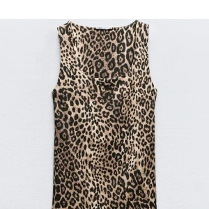 Leopardmönstrad ärmlös linne ifrån Zara - Snygg ärmlös klänning från Zara med leopardmönster i beige och svart. Modellen är kort och har en rundad halsringning. Perfekt för dig som vill sticka ut med ett djurmönstrat plagg.