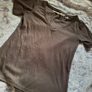 Svart ribbad T-shirt från lager 157 - Svart ribbad t-shirt från lager 157, med v-ringning. Sitter jättefint på