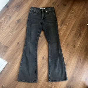 Svarta bootcut jeansbyxor - Snygga svarta jeansbyxor med bootcut passform och klassisk femficksdesign. Jeansen har en mörk tvätt och raka ben som blir vidare nedtill. Perfekta för dig som gillar en retroinspirerad look med lite extra edge.