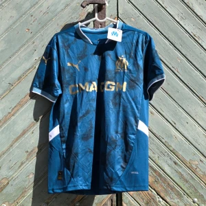 Marseille fotbollströja - Hej! Vi säljer just nu denna underbara Marseille tröjan till ett väldigt bra pris 😍Den är perfekt nu inför sommaren ☀️🌟Tröjan är i storlek S 👕Kontakta oss för mer information ℹ️ 