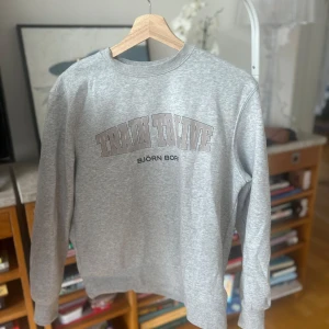 Grå sweatshirt från Björn Borg - Säljer en grå sweatshirt från Björn Borg med texten 'Train to Live' tryckt på framsidan. Tröjan har långa ärmar och en klassisk rund halsringning. Perfekt för en avslappnad stil.