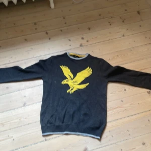 Grå lyle&scott 12-13 år  -  Säljer en grå lyle & scott tröja med en stor gul örn på framsidan. Tröjan har långa ärmar och ribbade kanter vid ärmslut och nederkant. Perfekt för en avslappnad stil. Storlek 12-13 år