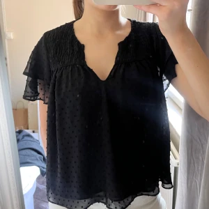 Svart blus med prickigt mönster - svart blus 