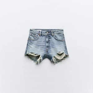 Blå jeansshorts med fransar - Snygga blå jeansshorts från Zara med fransiga kanter och en klassisk femficksdesign. Perfekta för en avslappnad stil. De har en hög midja och en sliten look som ger en trendig touch. (Ljuset gör att de ser orange ut i tonen)