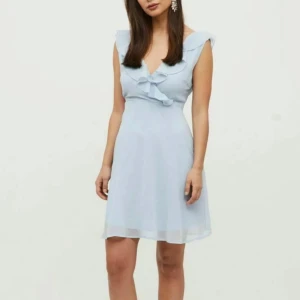 Ljusblå klänning från Vila - Säljer en söt ljusblå klänning från Vila med volangdetaljer och v-ringning. Klänningen är ärmlös och har en kort längd som passar perfekt för skolavslutningen✨✨ 