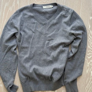 Grå tröja från Lacrosse - Säljer en stilren grå tröja från Lacrosse Premium Line. Tröjan har en v-ringad design och är tillverkad i ett mjukt material. Perfekt för en avslappnad men snygg look. Hör av dig vid intresse!