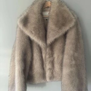 Beige pälsjacka från Neo Noir - Säljer en lyxig beige pälsjacka från Neo Noir. Jackan har en elegant design med långa ärmar och en mjuk, fluffig textur. Perfekt för att hålla sig varm och stilren under kyliga dagar. 🧥✨Nypris 1800kr.