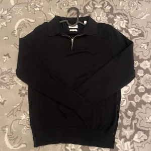 Tröja från These Glory Days - Säljer en stilren svart tröja från These Glory Days i bomull. Köpt på Volt för 1200. Stilren quarterzip, perfekt för en avslappnad look. Den är tillverkad i superior cotton för extra komfort. Säljer billigt! Nyskick! 