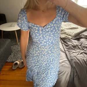 Blå blommig klänning - Söt blå klänning med vita blommor och korta ärmar, perfekt inför sommaren!! Helt ny❣️