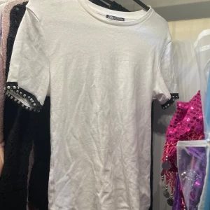 t-shirt från Zara  - Säljer en stilren vit t-shirt från Zara med korta ärmar och snygga pärldetaljer vid ärmsluten 💖 Perfekt för en trendig look. Knappt använd och är i storlek M men passa surr på mig som är en S💞💞 bara att höra av er vid frågor, kom gärna med bud 💫💫