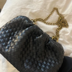 Svart flätad axelväska med kedja - säljer denna väska då jag inte använder den så mycket. Den går att ha som en axelremsväska men även bara på axel 