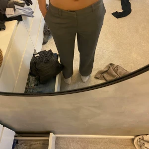 Grå byxor från Gina Tricot - Snygga grå byxor från Gina Tricot i storlek 36. De har en klassisk design med raka ben och en mellan hög midja. Perfekta för en stilren look.