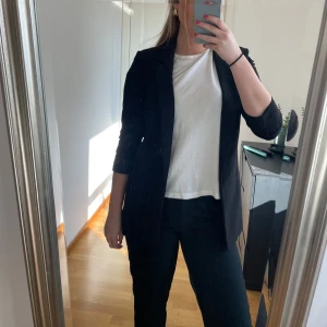 Svart kavaj - Snygg svart kavaj med trekvartsärm och klassisk design. Perfekt för en stilren look. Passar bra till både vardag och mer formella tillfällen.