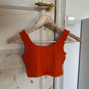 Orange från Gina Tricot - Säljer orange topp från Gina Tricot. Toppen är ärmlös och har en enkel design som passar perfekt till sommaren. 