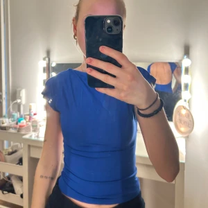 Blå topp med öppen rygg från Shein - Säljer en snygg blå topp från Shein med öppen rygg och korta ärmar. Perfekt för en kväll ute eller en somrig dag. Toppen är figurnära och ger en stilren look. 💙Den är aldrig använd!